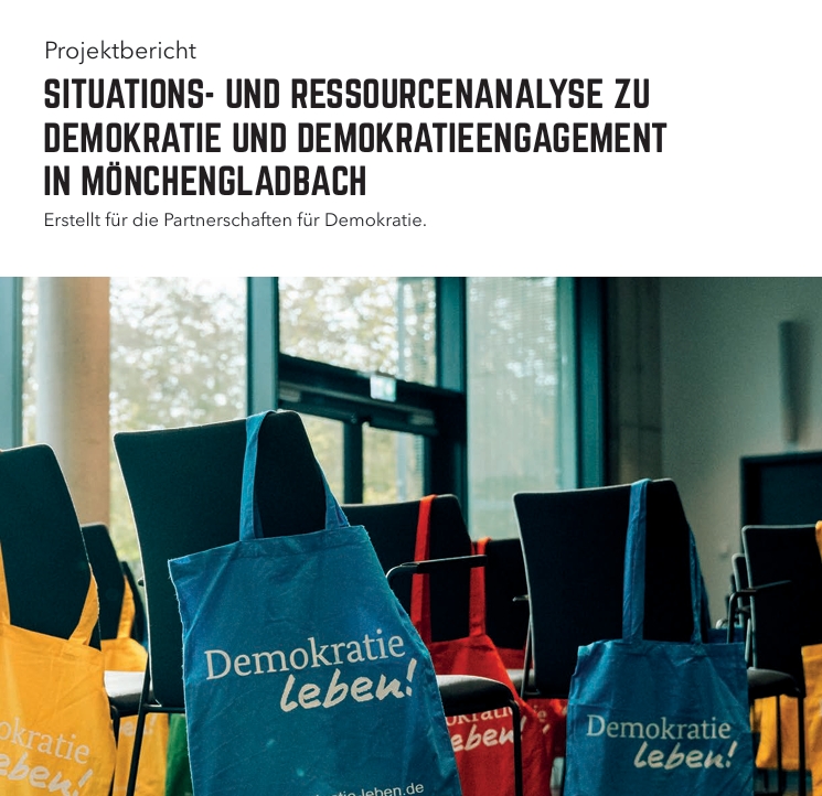 Titelblatt der Situations- und Ressourcenanalyse zu Demokratie und Demokratieengagement in Mönchengladbach. Im oberen Bereich steht der Titel „Situations- und Ressourcenanalyse zu Demokratie und Demokratieengagement in Mönchengladbach“ sowie der Hinweis „Erstellt für die Partnerschaften für Demokratie“. Darunter ist ein Foto eines Veranstaltungsraums mit mehreren Stuhlreihen zu sehen. Über den Rückenlehnen hängen farbige Stofftaschen mit dem Aufdruck „Demokratie leben!“, darunter blaue, rote, gelbe und grüne Taschen. Im Hintergrund sind große Fenster und Tageslicht sichtbar.
